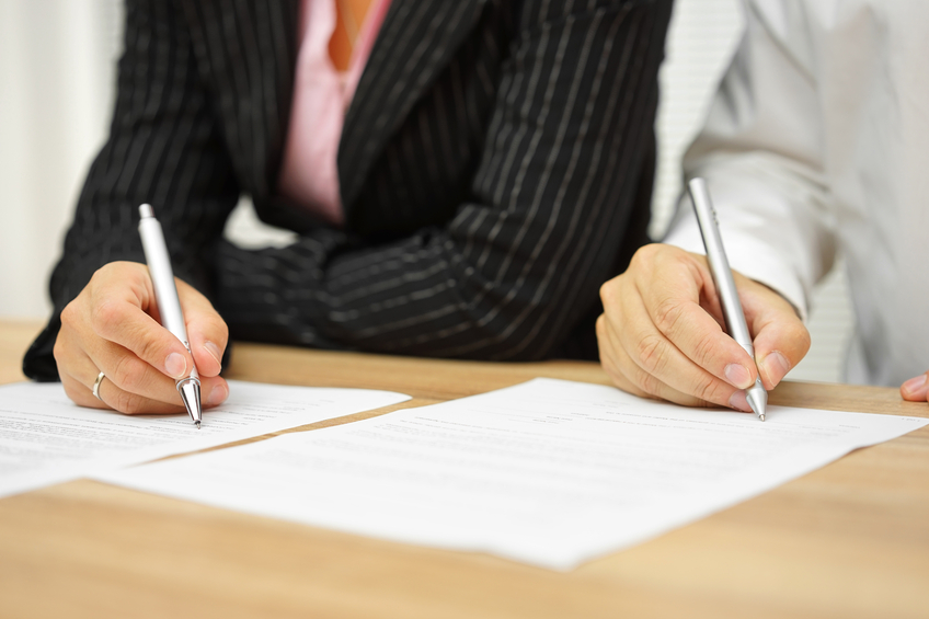 businesswoman and businessman signing contract in the office